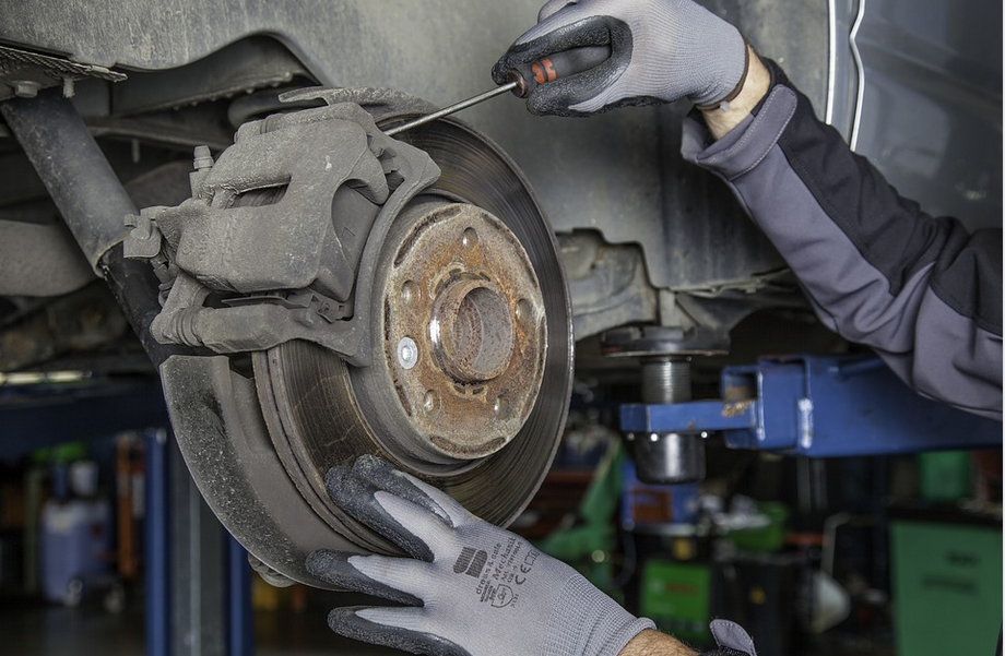 a mechanic repairing car disc pads